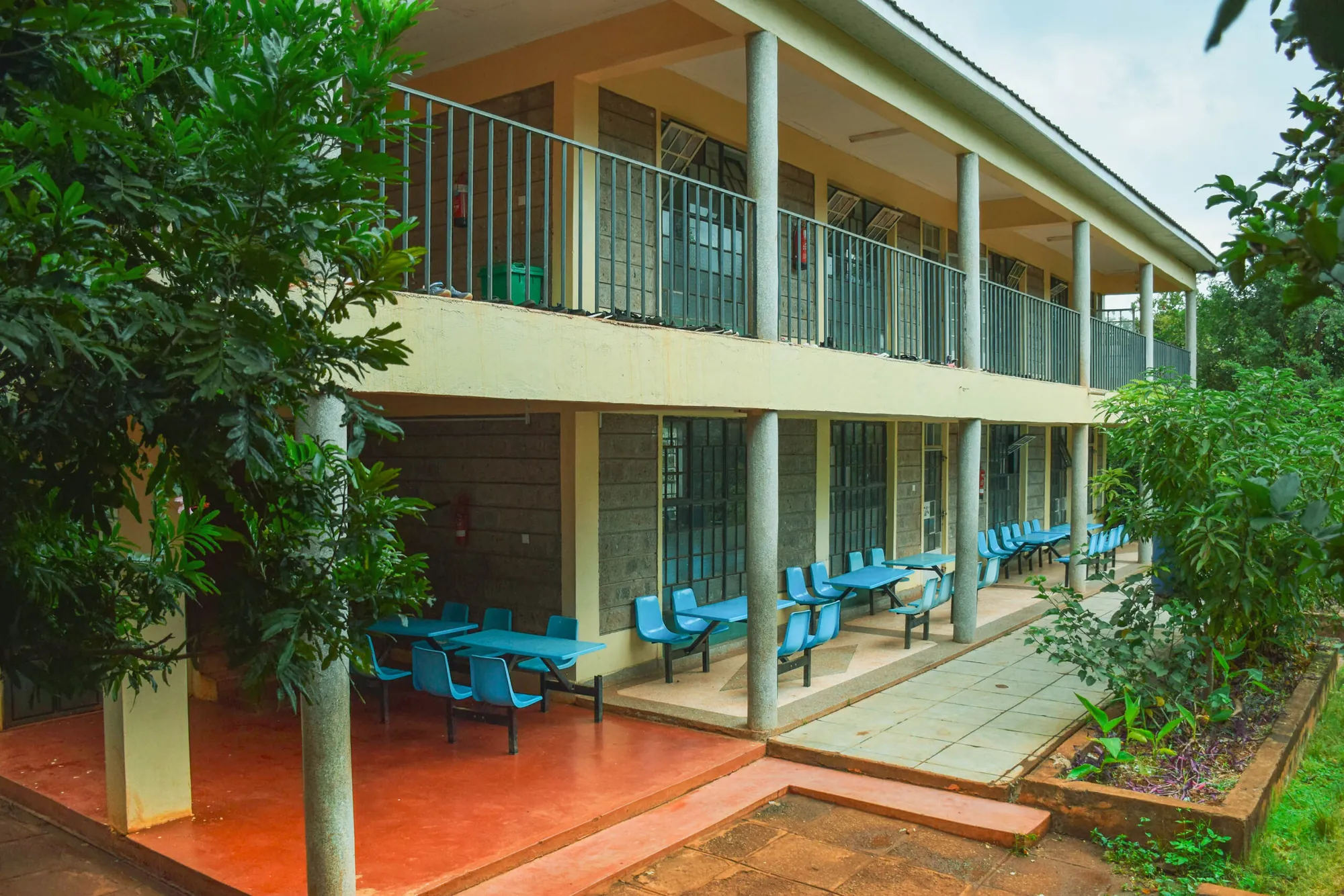 Veranda of a classroom block with blue chairs and tables