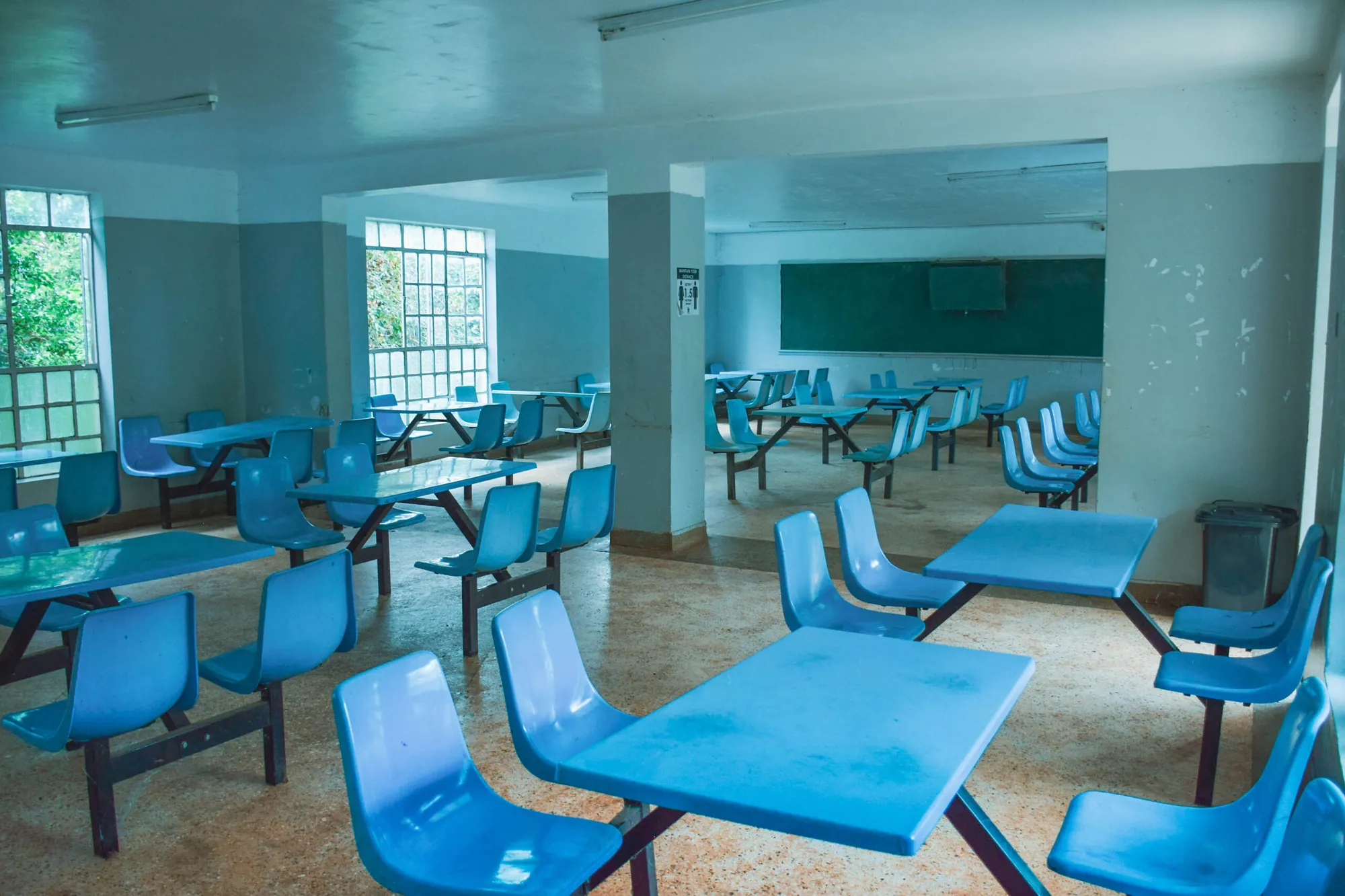Dining hall with rows of blue tables and chairs