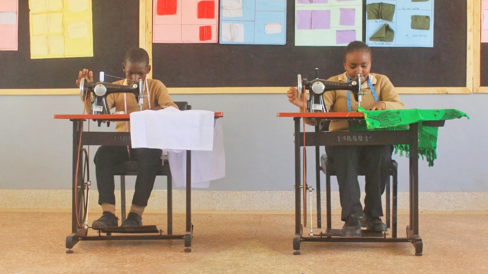 Two pupils sewing at machines in a textiles classroom