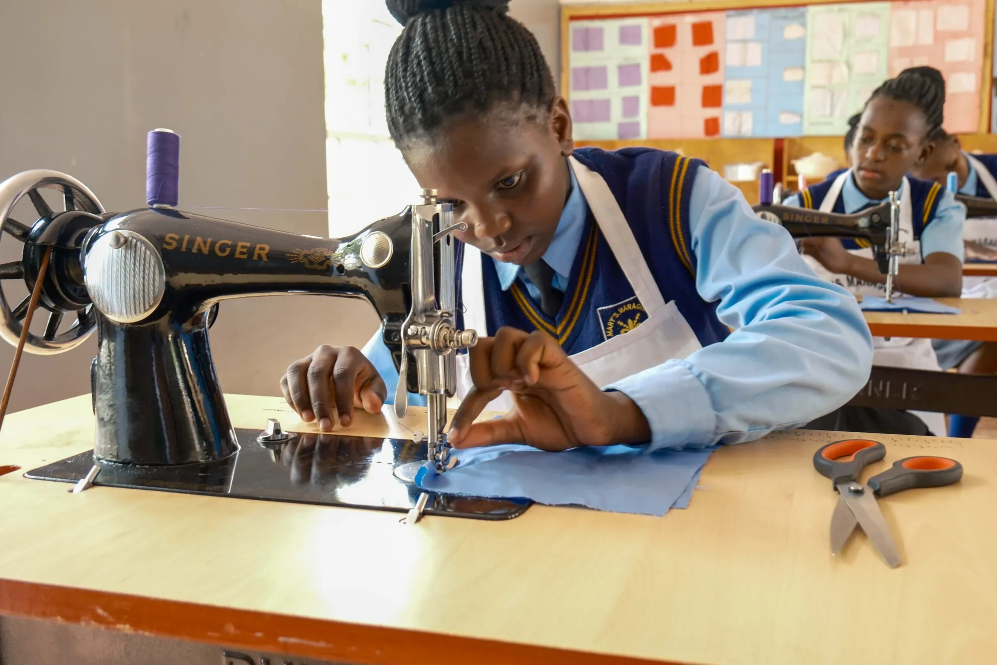 A student operating a sewing machine
