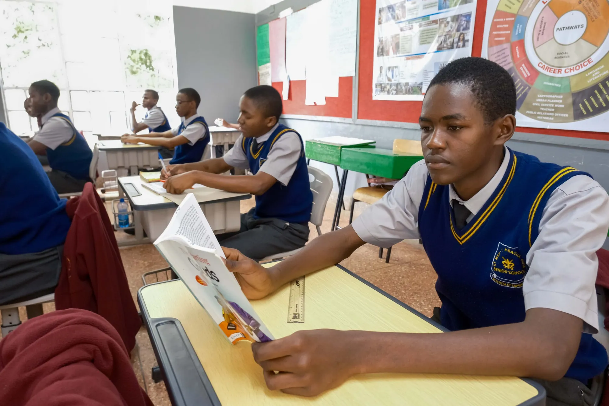 A student reading a textbook at her desk