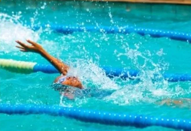 A swimmer mid-stroke in a pool lane